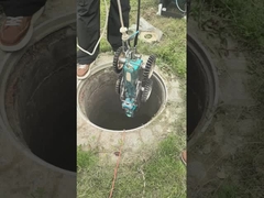 Un robot de surveillance qui descend vers le trou d'égout.